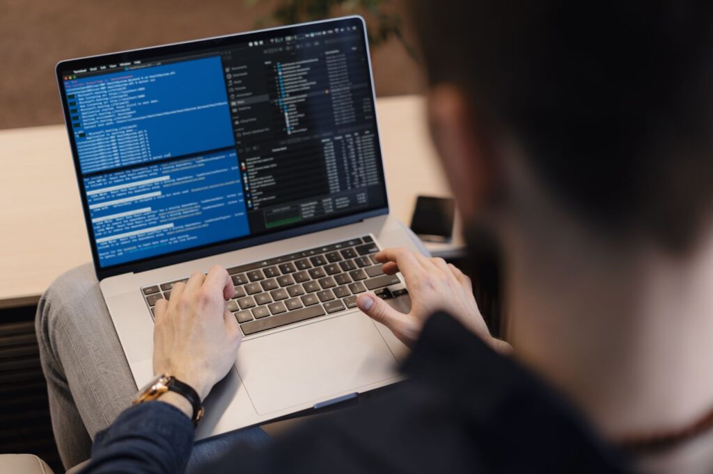 Close up of man writing code on the laptop