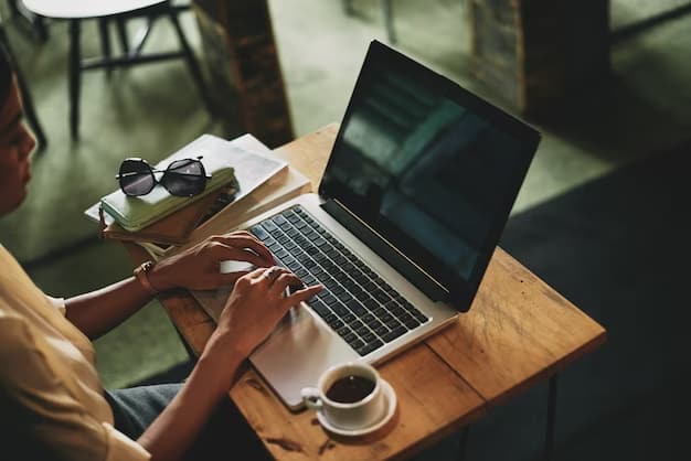 A girl working at her computer with a cup of coffee and a notepad